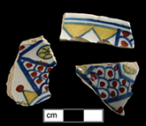 Hollow vessel painted polychrome with red, yellow and blue motif on dead white background - May have been made in Bristol in the early 18th century in a fashion known as Bristol blue-red-green - This style characterized by rich colors on an almost dead white background (Britton 1982:209). Pieces illustrated in Britton date between c. 1705 (p. 86) and the 1720s and 1730s.